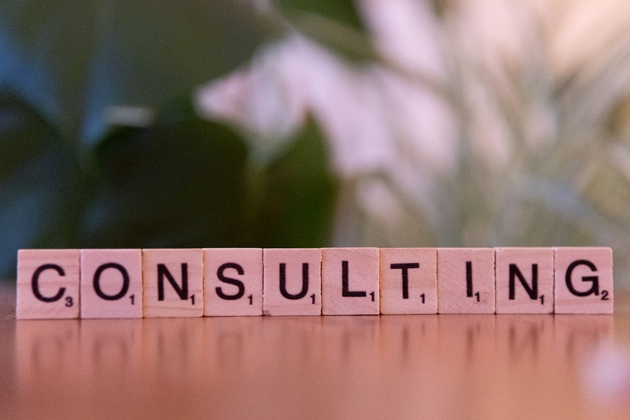 services-01 Wooden letter tiles spelling 'Consulting' with a blurred background. Ideal for business concepts.